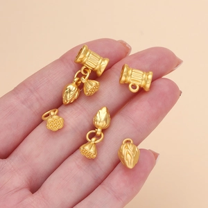 Detail of matte gold lotus pendants and textured connector beads for DIY jewelry making