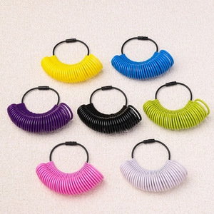 Close-up of multicolor ring sizer gauges with various scales on a textured surface