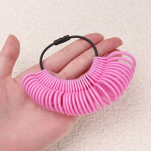 Pink plastic ring sizer tool set being held for measuring finger sizes accurately