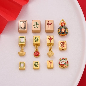 Close-up of golden Chinese Mahjong beads and lucky charms on a white plate