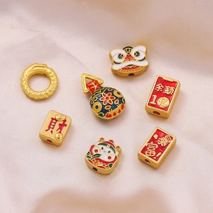 Detail of traditional Chinese gold-plated charms including lion dance and fortune bag