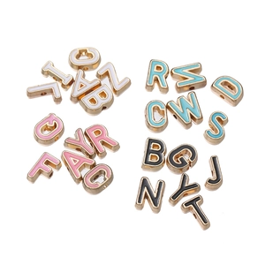 Macro view of 10mm alloy alphabet beads with gold base and colorful enamel fill