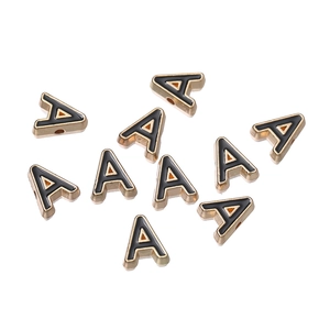 Macro detail of 10mm gold alloy letter A bead with black enamel oil for DIY jewelry