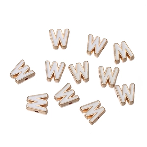 Detail of white enamel letter W beads with gold trim and side threading holes for DIY jewelry