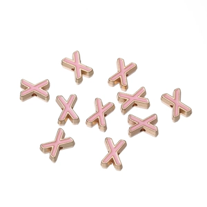 Close-up of pink enamel letter X charms with gold alloy edges for DIY jewelry making