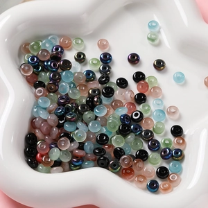 Détails de perles de verre colorées de 3x6mm pour bijoux DIY dans un bol blanc