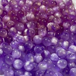 Macro shot of 8-12mm purple mermaid resin beads with cat eye effect for DIY jewelry