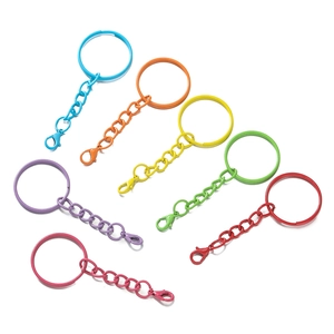 Close-up of assorted colorful painted metal lobster clasp keychains on white background