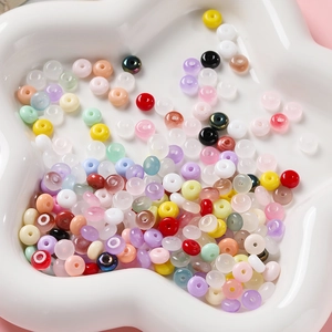Gros plan de perles en verre colorées 3x6mm pour bijoux DIY dans un plateau blanc