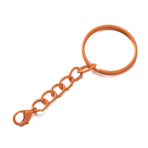 Macro detail of vibrant orange lacquered lobster clasp and chain for DIY keychains