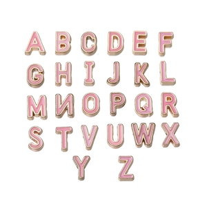 Flat lay of pink enamel and gold-plated 10mm alloy alphabet charms A-Z for DIY jewelry
