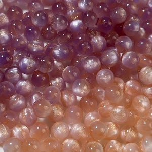 Macro detail of gradient resin mermaid beads with shimmering internal sparkles