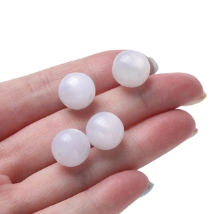 Close-up of 8mm to 12mm white resin beads with smooth pearl finish for DIY jewelry
