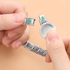 Macro view of stainless steel Italian charm bracelet with green enamel heart links