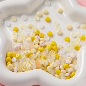 Vue détaillée de perles de verre pastel 3x6mm dans un plateau en céramique pour bijoux DIY