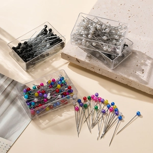 Close-up of multi-colored pearl head sewing pins and transparent storage cases