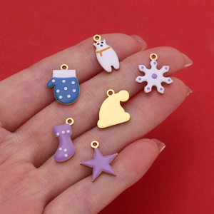 Macro detail of six colorful Christmas charms held in hand against a red background