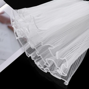Macro view of white wavy tulle ribbon with pearl edges for bouquet and gift decoration