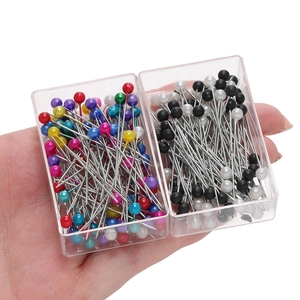 Macro detail of colorful and black-white pearl head straight pins in plastic cases
