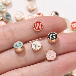 Vista macro de abalorios de letras coloridas de aleación para creación de joyas DIY
