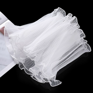 Close-up detail of white wavy pleated mesh lace ribbon with delicate pearl edge trim