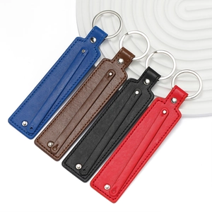 Gros plan de quatre porte-clés en cuir PU coloré avec texture litchi et anneaux métal