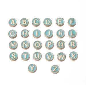 Detalle macro de 26 cuentas de letras en esmalte azul claro con bordes dorados