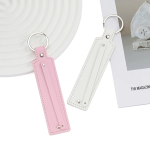 Détail de porte-clés en cuir PU rose et blanc avec coutures et anneaux métalliques