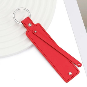 Gros plan du porte-clés en cuir PU rouge avec rivet argenté et anneau métallique