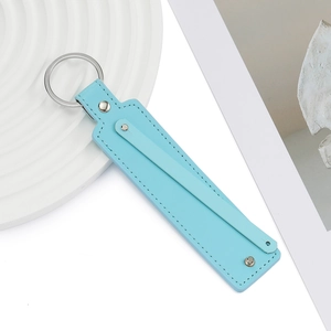 Détail d'un porte-clés en similicuir bleu clair avec anneau métallique et coutures nettes