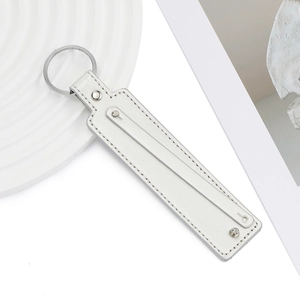 Vue détaillée d'un porte-clés en cuir PU blanc avec anneau en métal argenté et coutures