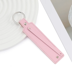 Détail d'un porte-clés en cuir PU rose avec surpiqûres fines et anneau argenté
