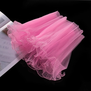 Detail of pink pleated wavy tulle mesh fabric with delicate pearl trim for DIY bouquets