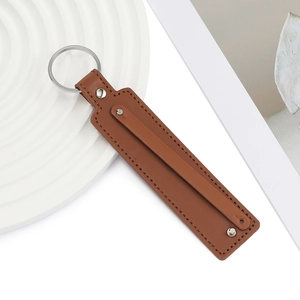 Gros plan du porte-clés en cuir PU marron avec anneau argenté et détails de couture