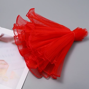Detail of red wavy pleated mesh fabric with pearl edges for bouquet and gift decoration