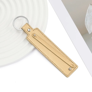 Gros plan du porte-clés en cuir PU doré avec rivets argentés et coutures soignées