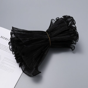 Macro detail of black pleated wavy gauze ribbon with pearl edges for bouquet decoration