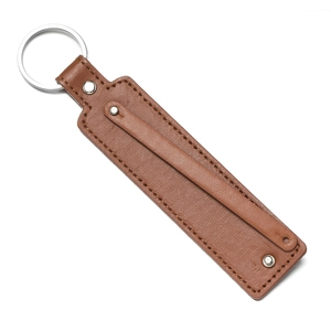 Vue détaillée d'un porte-clés en cuir marron texturé avec rivets et anneau en métal argent