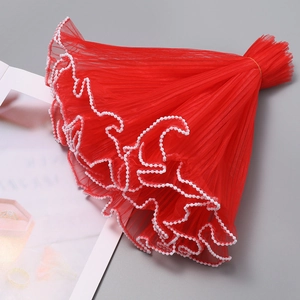 Detail of red pleated mesh fabric with white pearl edge trim for floral gift wrapping