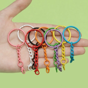Bunter lackierter Metall-Schlüsselanhänger mit Karabiner und Ring in der Hand