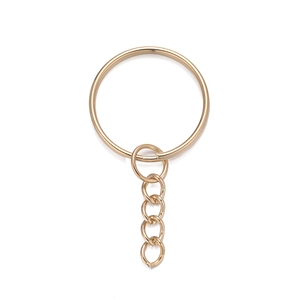 Detailed view of polished golden metal key ring with attached four-link chain component