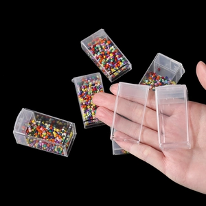 Close-up of clear plastic storage boxes with colorful seed beads for DIY jewelry making