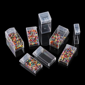 Detailed view of clear plastic storage boxes with lids and colorful beads inside