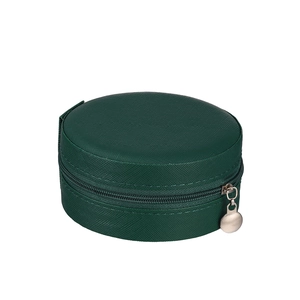 Close-up of circular dark green jewelry storage case with textured fabric and metal zipper