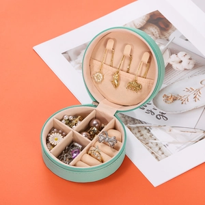 Interior layout of a mint green round travel jewelry organizer with multiple storage slots