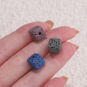 Macro shot of square lava stone beads in purple and grey with porous texture for DIY