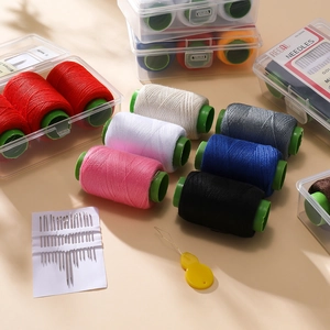 Portable sewing kit with colorful polyester thread spools, needles, and threader in a box