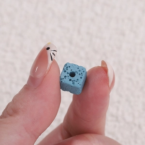 Macro shot of a blue cube-shaped porous lava stone bead for essential oil jewelry DIY