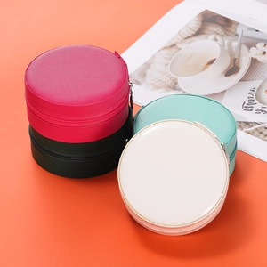 Detail of round portable jewelry boxes with cross-grain texture and zipper closure