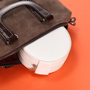 White mini jewelry box shown inside a handbag for portable travel storage